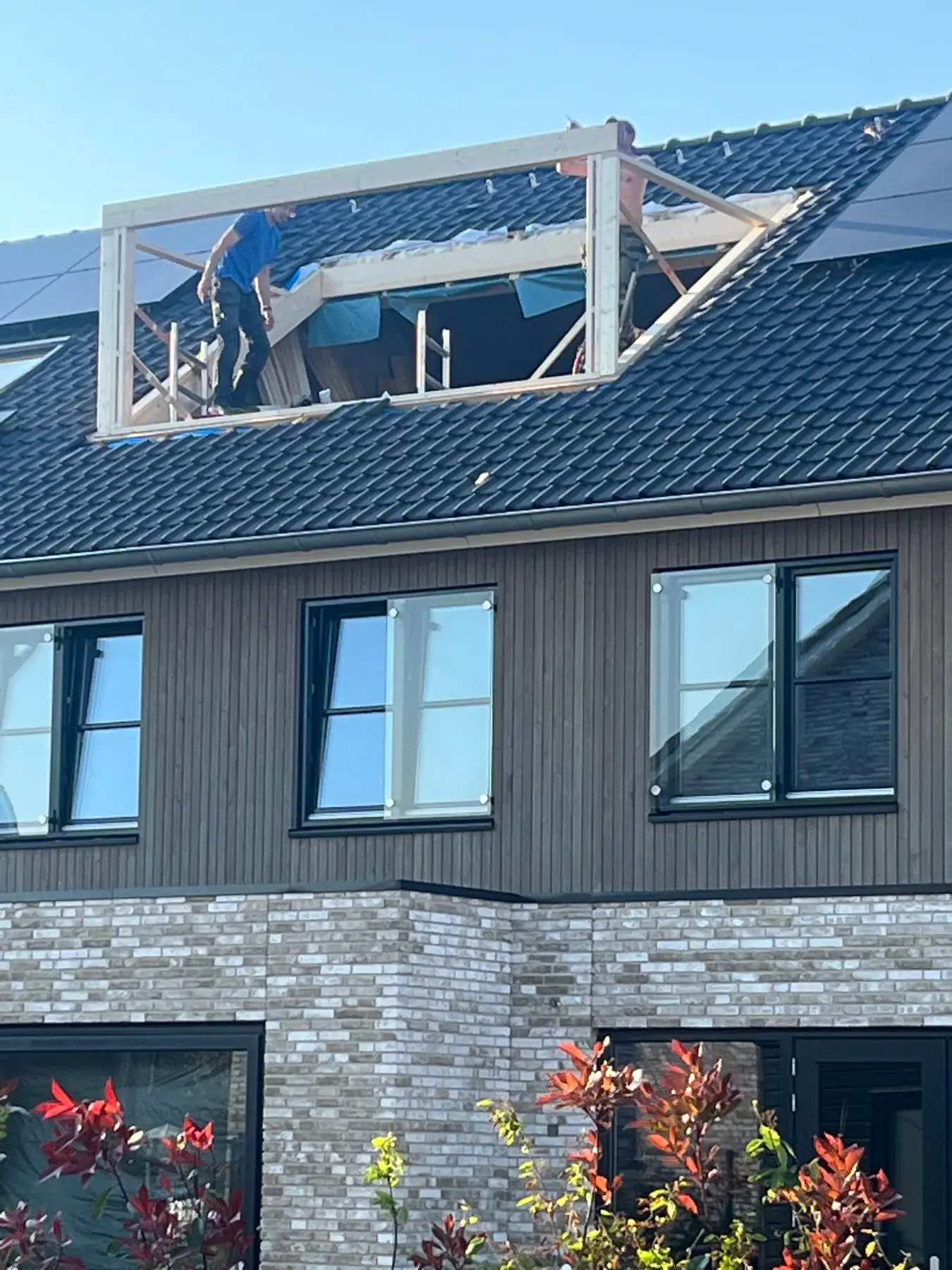 Timmerman werkt aan het frame van een dakkapel in een opengelegd dakvlak