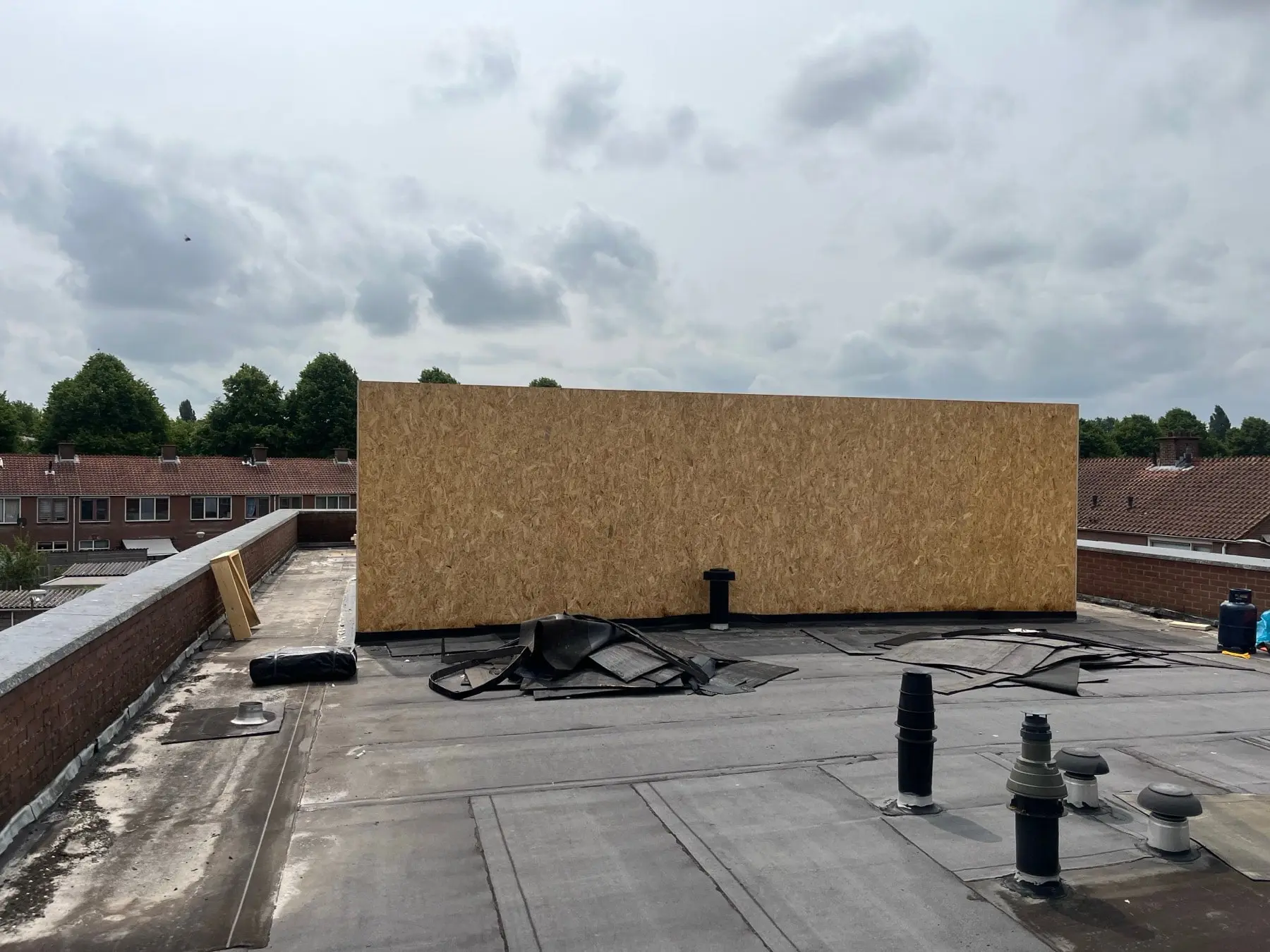 Dakopbouw in plaatmateriaal op een plat dak, met de bestaande dakbedekking eromheen