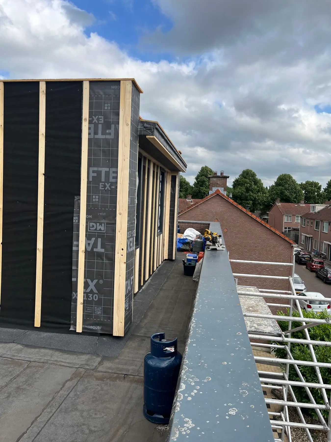 Dakopbouw in aanbouw met dampopen folie en houten regelwerk, gezien over het platte dak